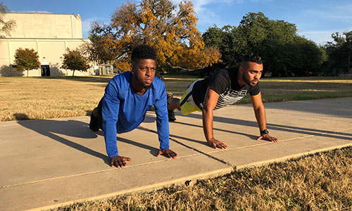 two men doing push-ups